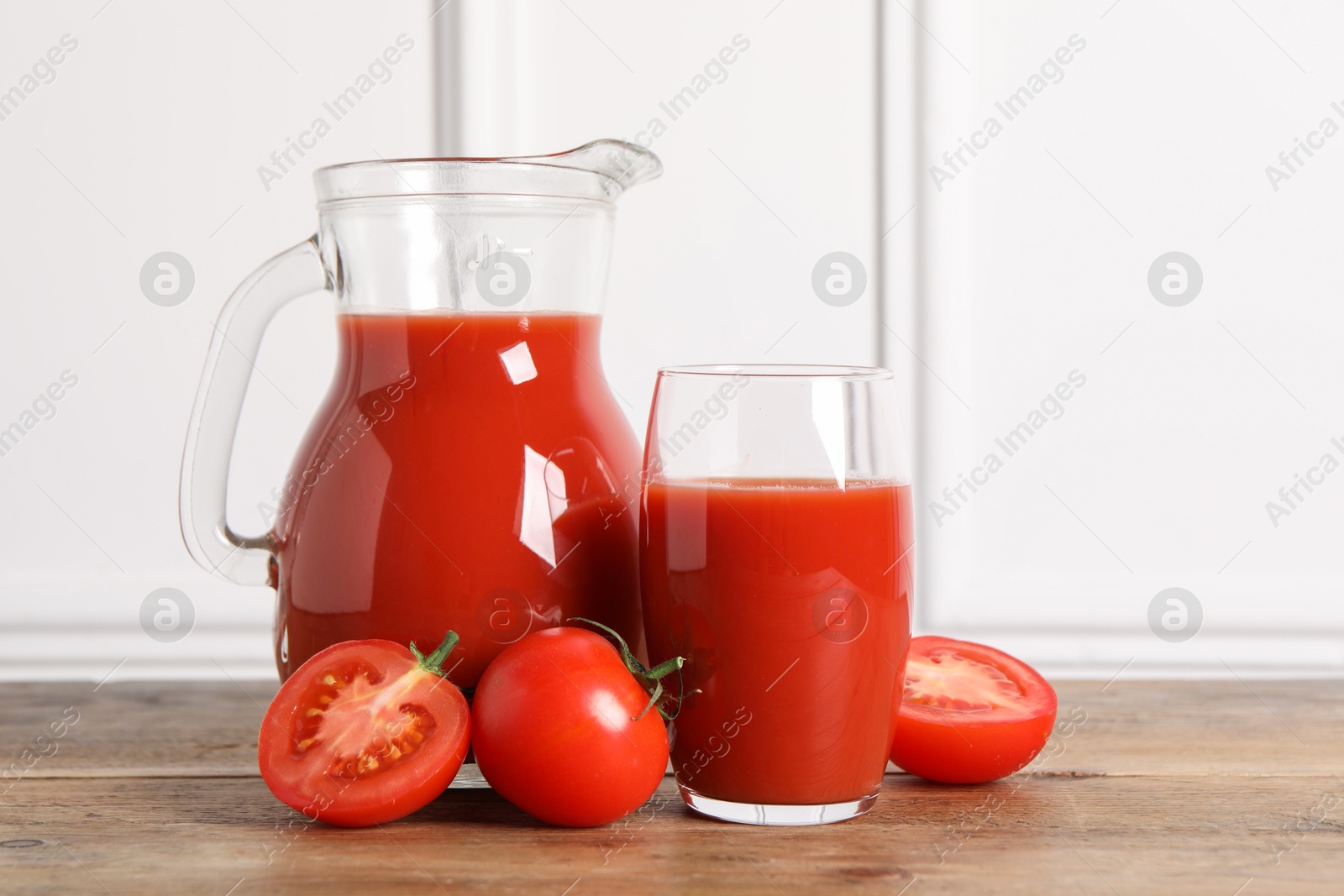 Photo of Tasty tomato juice and fresh vegetables on wooden table