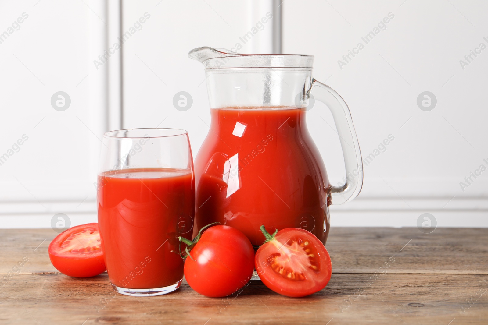 Photo of Tasty tomato juice and fresh vegetables on wooden table