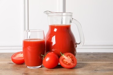 Tasty tomato juice and fresh vegetables on wooden table