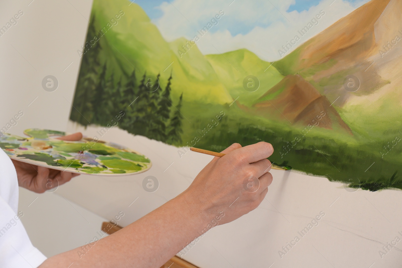 Photo of Woman drawing landscape with brush in studio, closeup