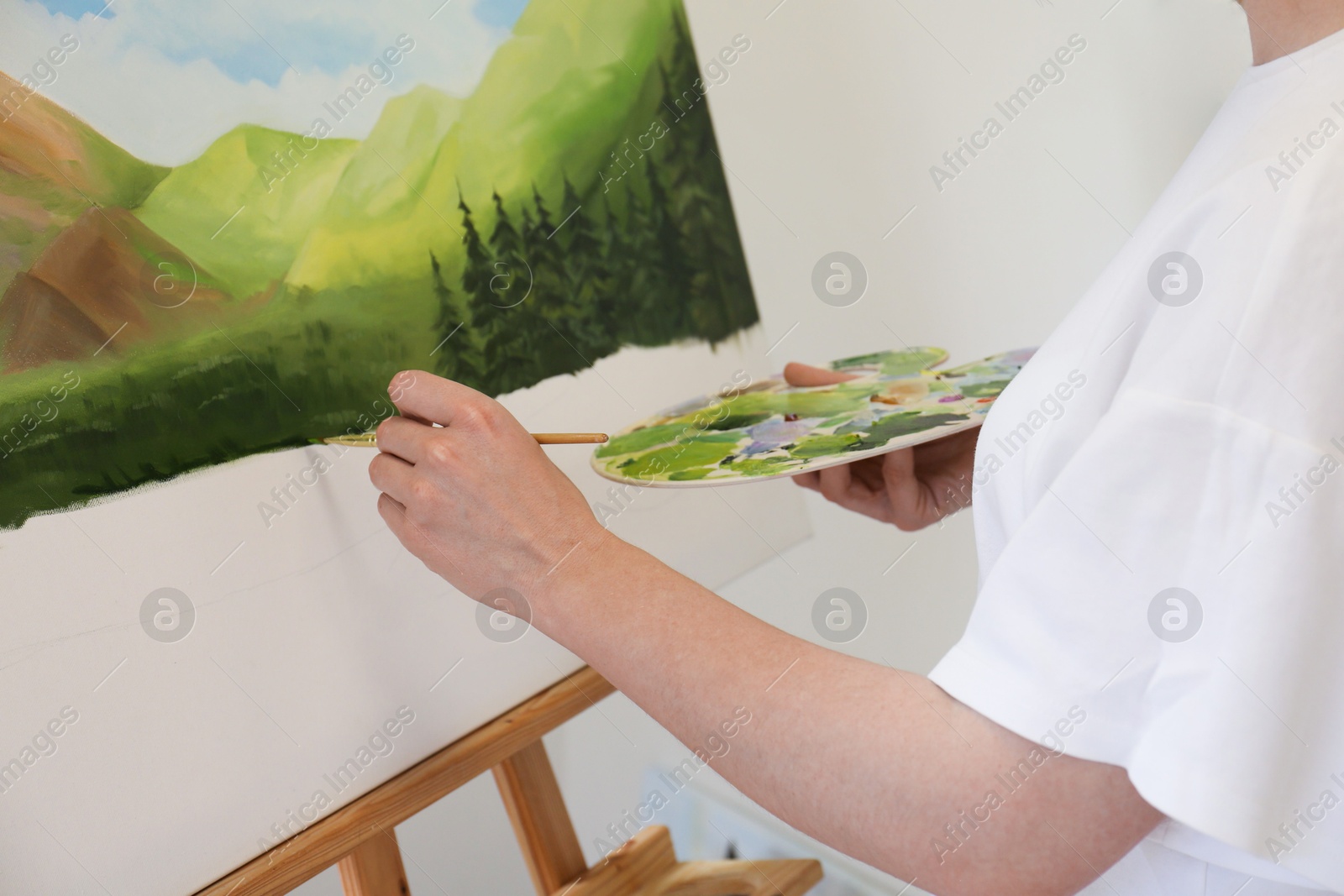 Photo of Woman drawing landscape with brush in studio, closeup