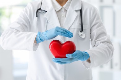 Photo of Doctor with red heart in clinic, closeup