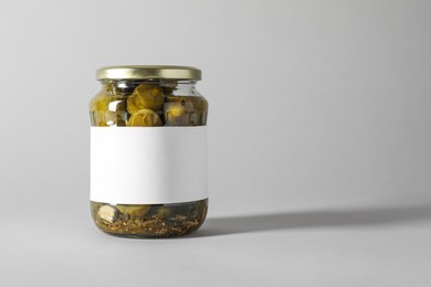 Photo of Pickled cucumbers in jar on light background. Space for text