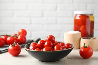 Tasty pickled tomatoes, fresh vegetables and spices on light grey table