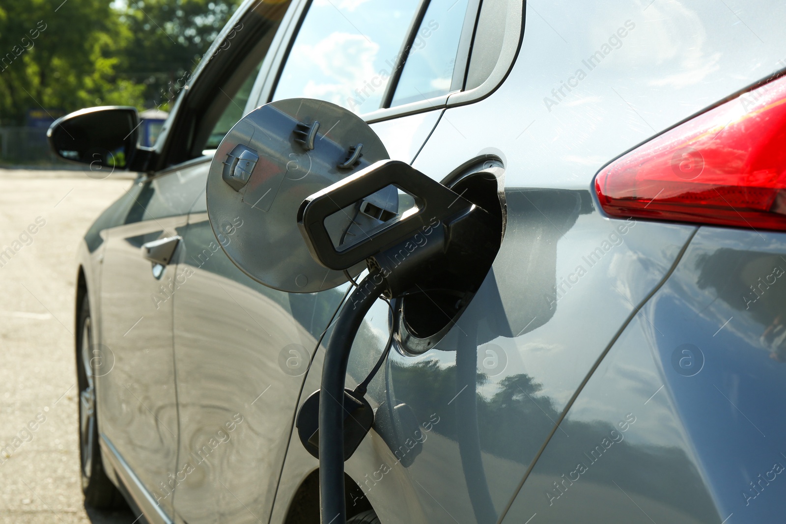 Photo of Charging modern electric car from station outdoors