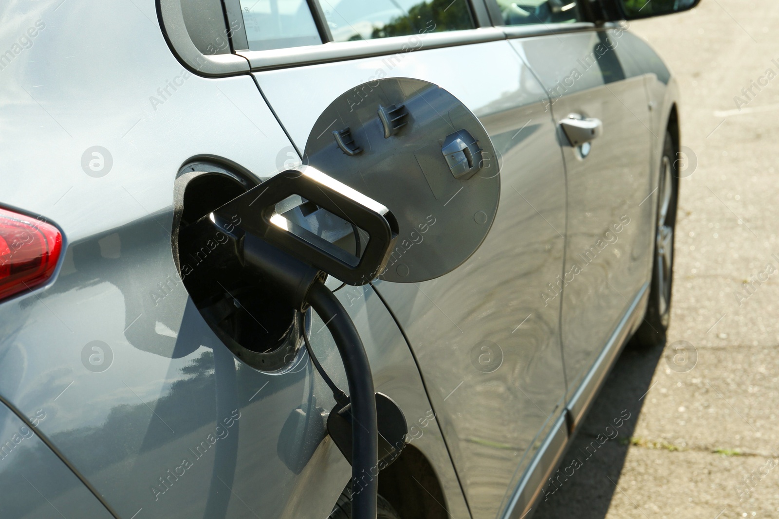 Photo of Charging modern electric car from station outdoors