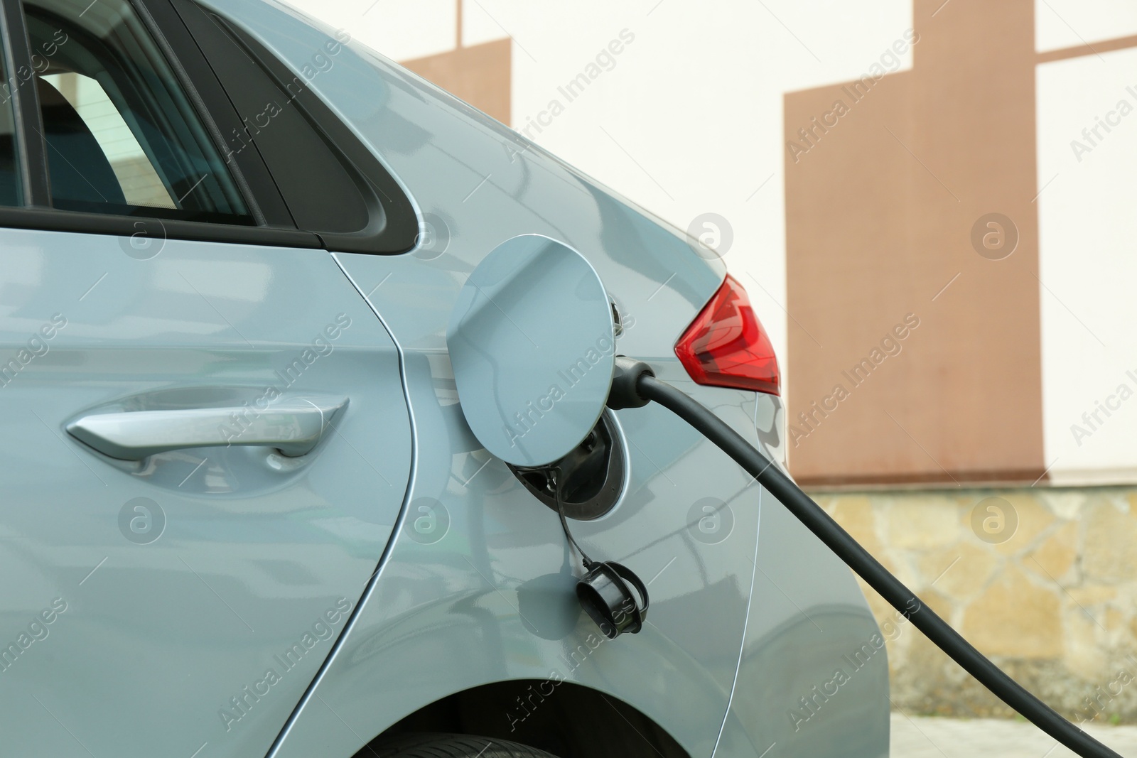 Photo of Modern electric car charging from station outdoors