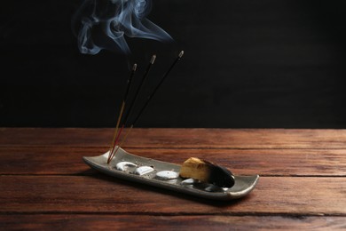 Aromatic incense sticks smoldering on wooden table. Space for text