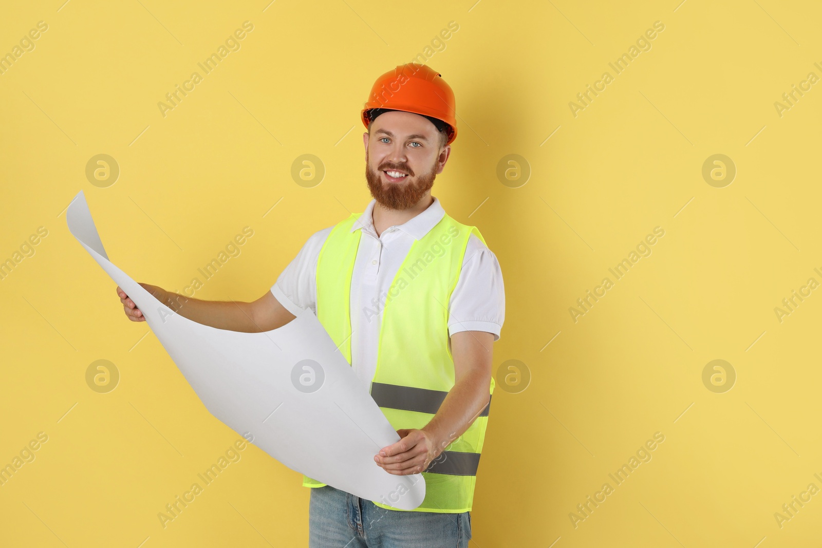 Photo of Engineer in hard hat with draft on yellow background, space for text