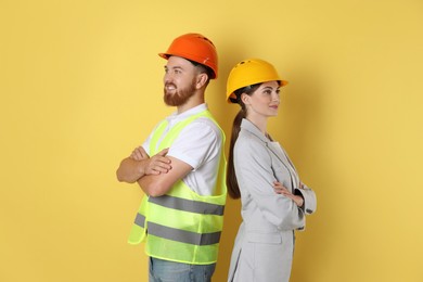 Engineers in hard hats on yellow background