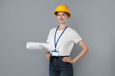Photo of Engineer in hard hat with drafts on grey background