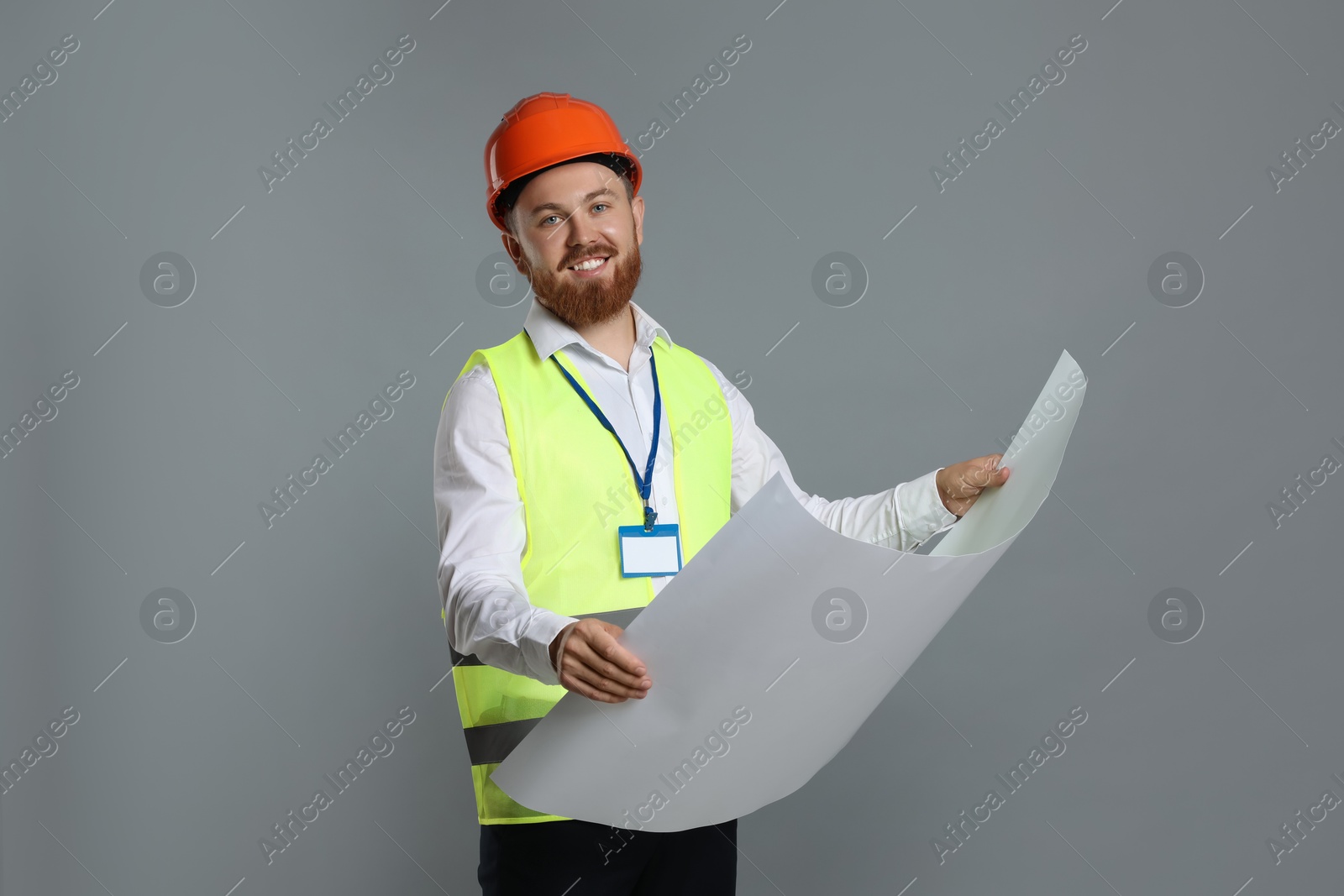 Photo of Engineer in hard hat with draft on grey background