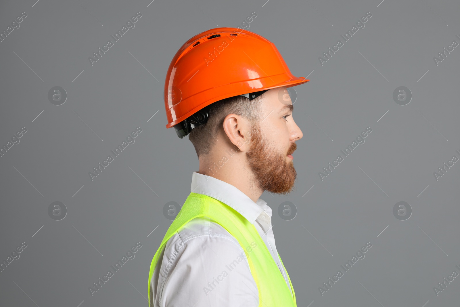 Photo of Engineer in hard hat on grey background