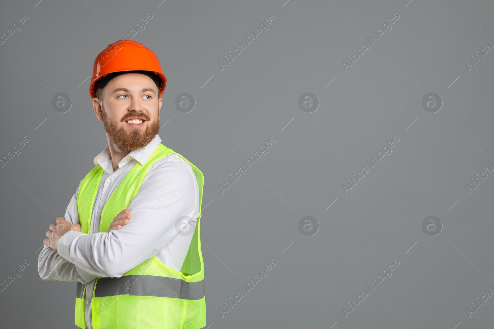 Photo of Engineer in hard hat on grey background, space for text