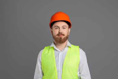 Photo of Engineer in hard hat on grey background