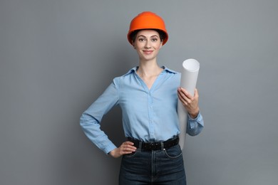 Photo of Engineer in hard hat with draft on grey background