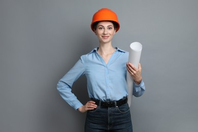 Engineer in hard hat with draft on grey background