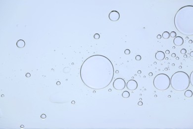 Photo of Sample of cosmetic oil on white background, macro view