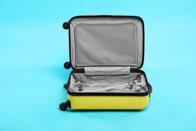 Photo of Open empty suitcase on light blue background