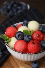 Tasty watermelon and melon balls with blueberries in bowl on table, closeup