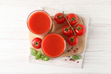 Tasty tomato juice in glasses with fresh vegetables and spices on white wooden table, flat lay