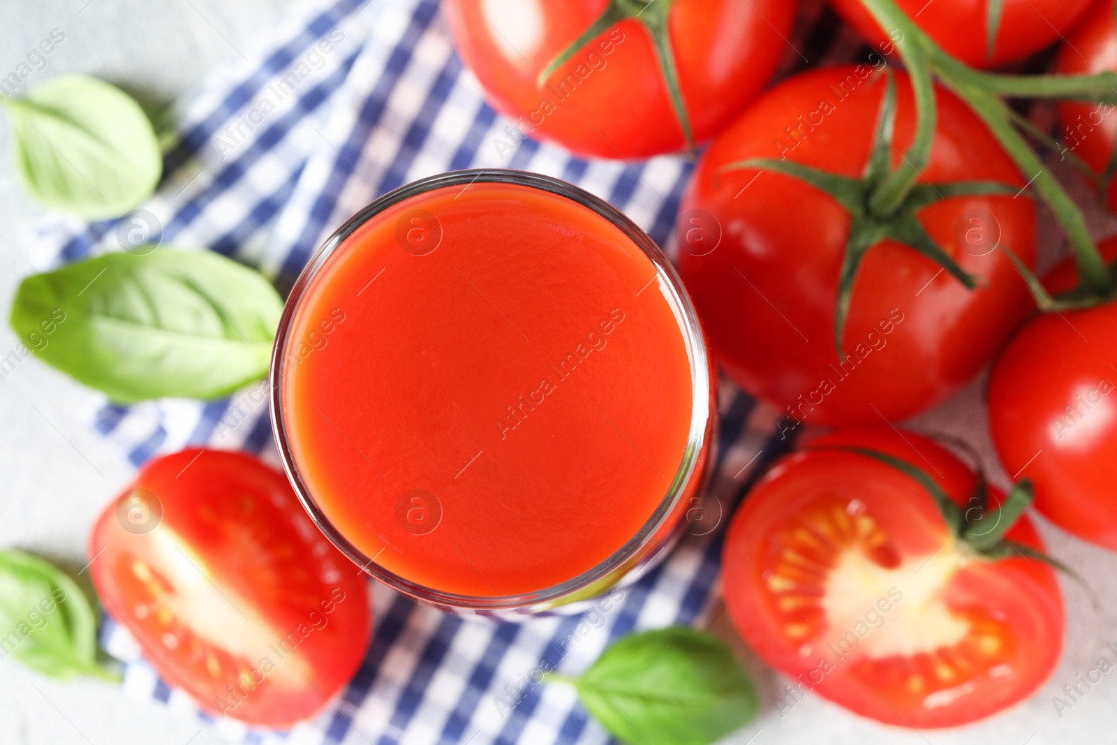 Photo of Fresh tomato juice in glass on light table, top view