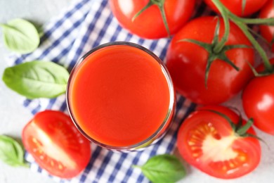 Fresh tomato juice in glass on light table, top view