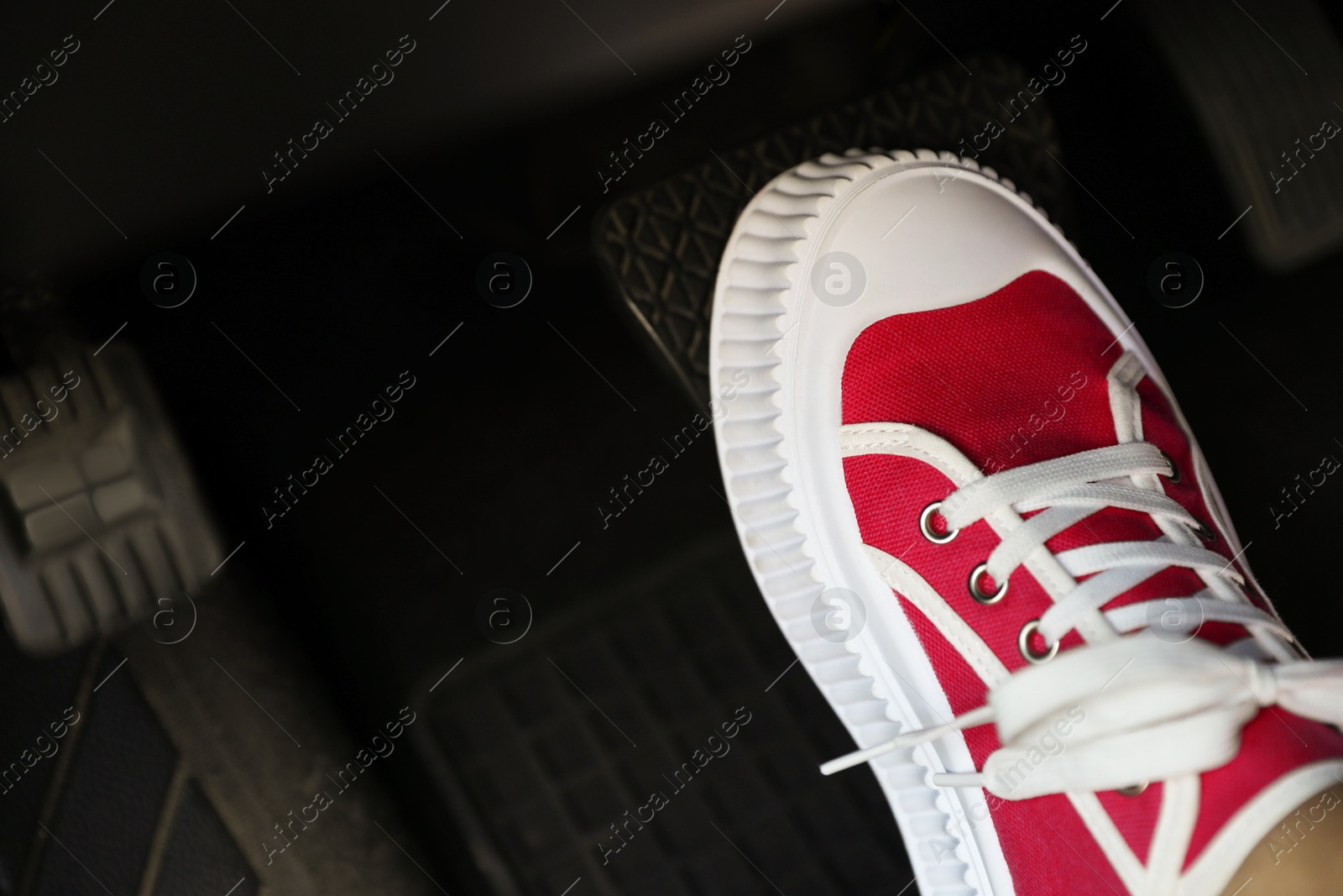 Photo of Woman pushing on pedal of car brake, closeup