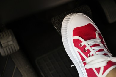 Photo of Woman pushing on pedal of car brake, closeup