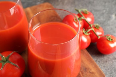 Tasty tomato juice in glasses and fresh vegetables on table, closeup