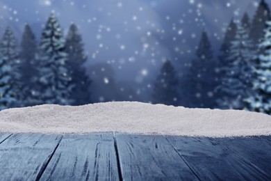 Image of Wooden table with snow in forest, space for text