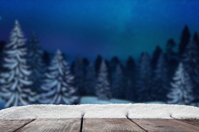 Image of Wooden table with snow in forest, space for text