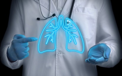 Image of Doctor pointing at virtual lungs on black background, closeup