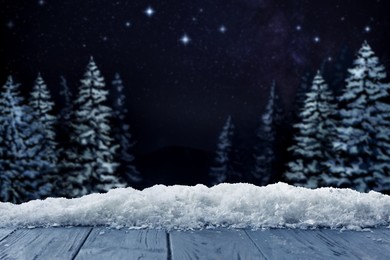 Image of Wooden table with snow in forest, space for text