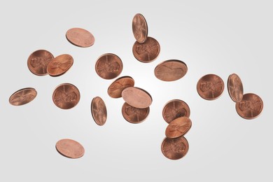 Image of United States one cent coins in air on light grey background