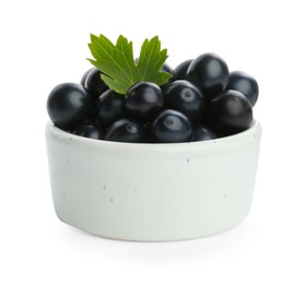 Photo of Bowl of ripe blackcurrants and green leaf isolated on white