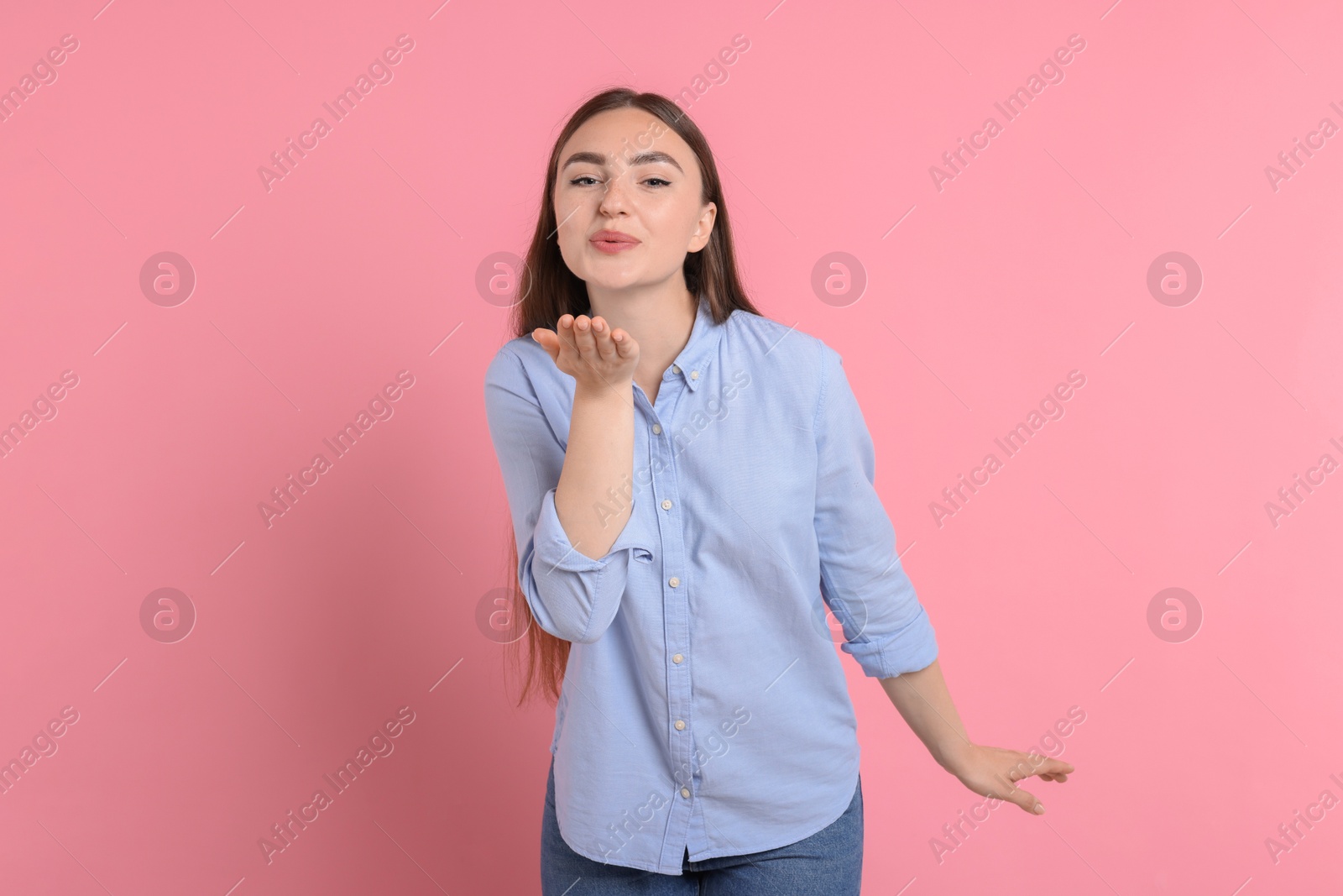 Photo of Beautiful woman blowing kiss on pink background