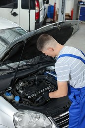 Auto mechanic fixing car at automobile repair shop