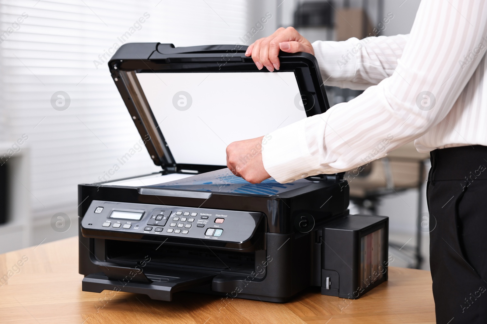 Photo of Woman using modern printer at workplace indoors, closeup