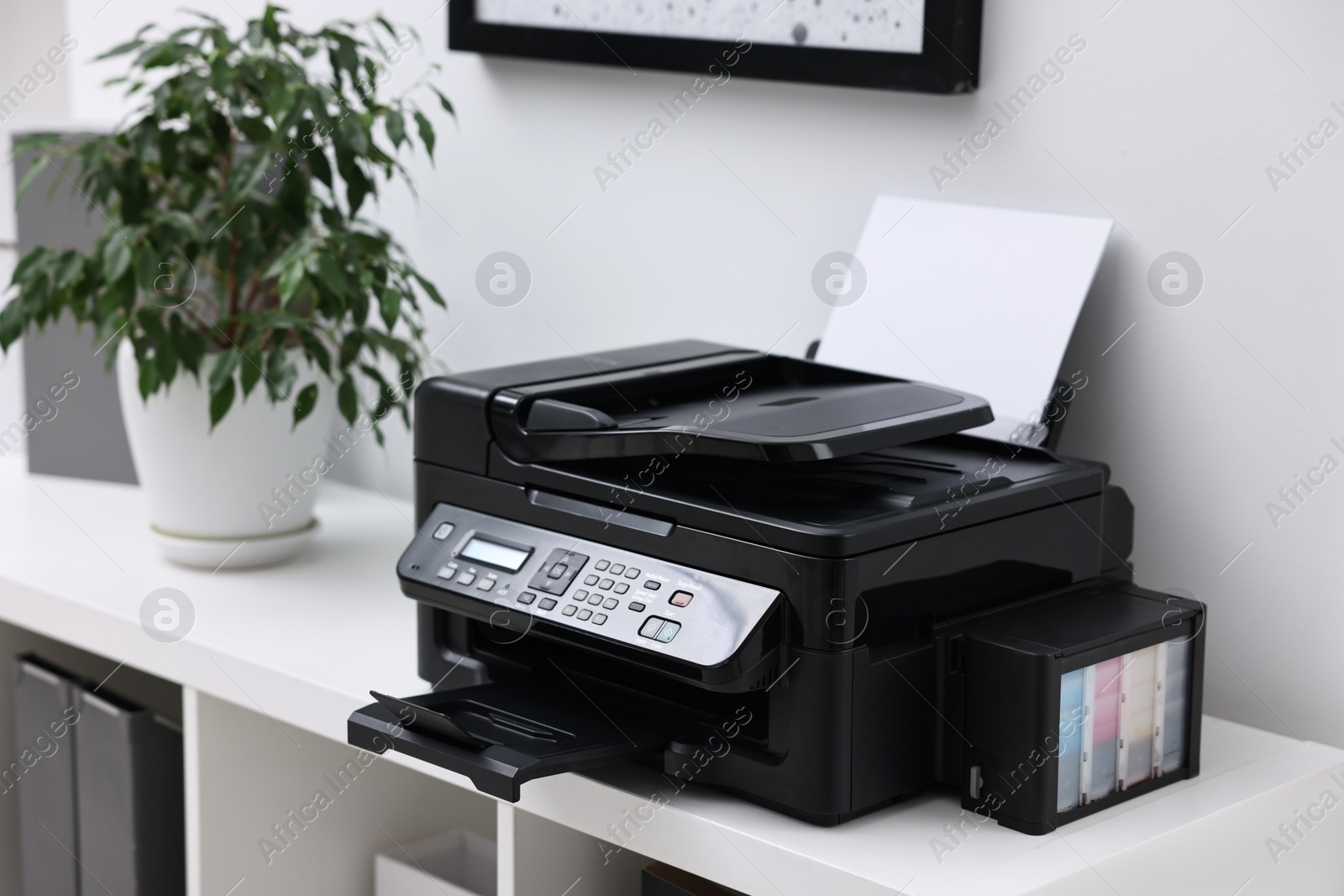 Photo of Modern printer with paper on table in office