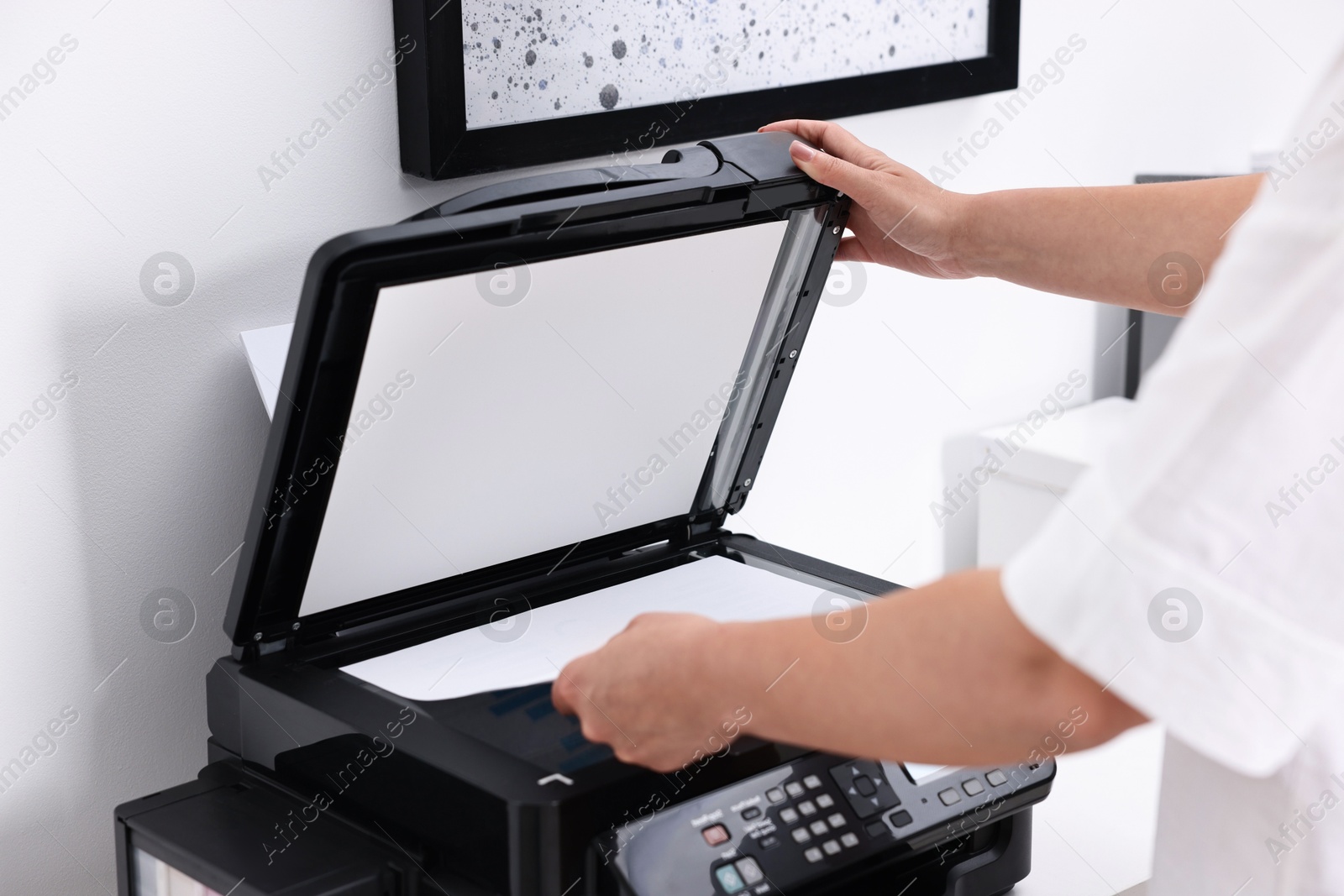 Photo of Woman using modern printer at workplace indoors, closeup