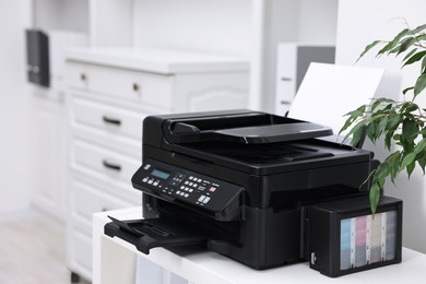 Photo of Modern printer with paper on table in office