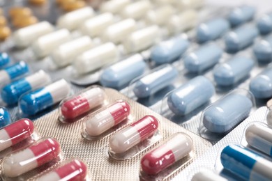 Photo of Antibiotic pills in blisters as background, closeup