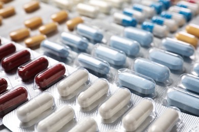 Photo of Antibiotic pills in blisters as background, closeup