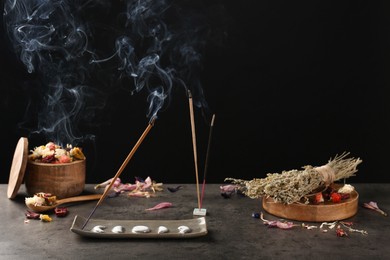 Photo of Aromatic incense sticks smoldering on grey table