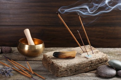 Photo of Aromatic incense sticks smoldering on wooden table