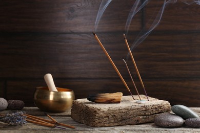 Photo of Aromatic incense sticks smoldering on wooden table