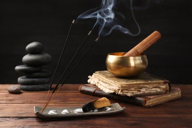 Photo of Aromatic incense sticks smoldering on wooden table