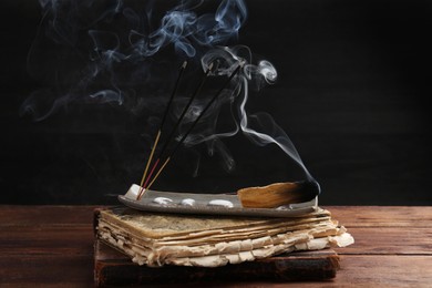 Aromatic incense sticks smoldering on wooden table