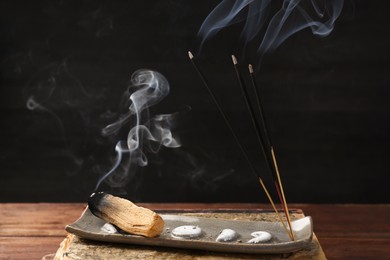 Aromatic incense sticks smoldering on wooden table